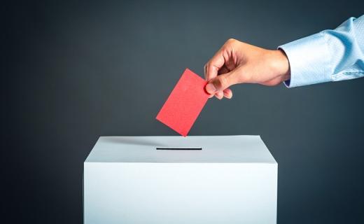 Bulletin glissé dans une urne électorale