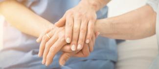 Mains d'une infirmière tenant la main d'une patiente